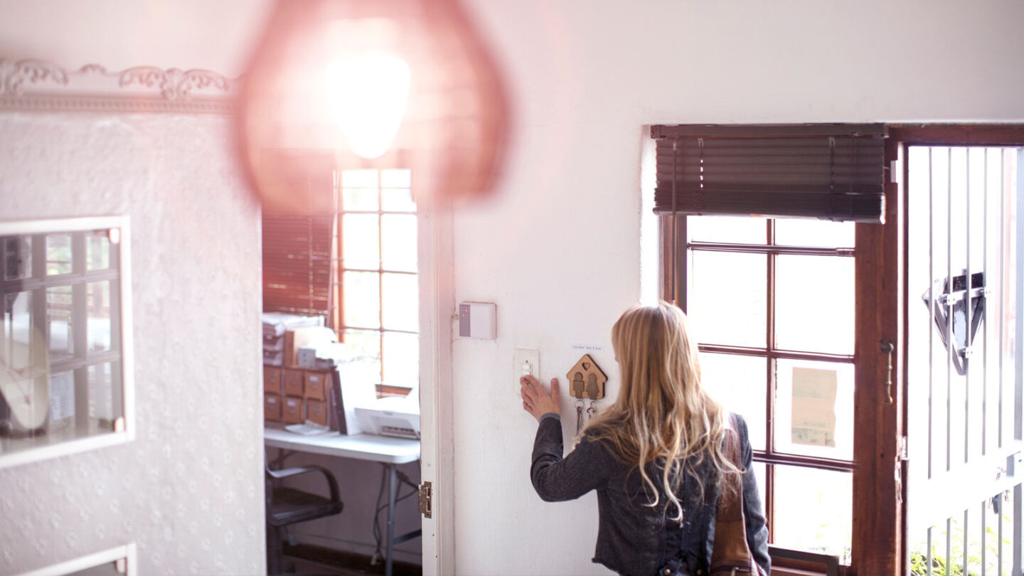 A women turns on a light in her home.