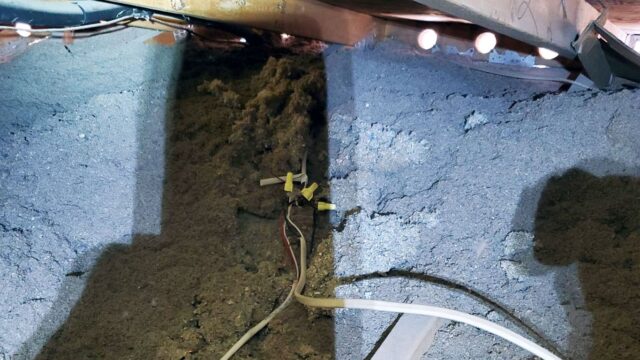 Attic space with insulation and exposed electrical wiring visible.